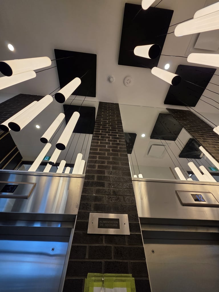 Upward view of modern kitchen with stainless steel appliances, white and black cabinetry, and black tile flooring
